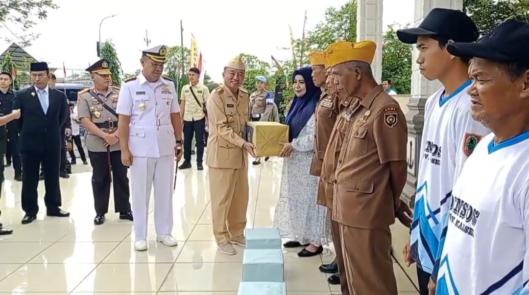 Gubernur Kalimantan Selatan H. Muhidin menyerahkan bingkisan secara simbolik kepada keluarga Pahlawan Nasional KH. Hasan Basri. 