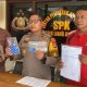 Petugas Polsek Liang Anggang menunjukkan barang bukti penipuan online oleh napi Lapas Tanjung: dua ponsel, buku tabungan, dan ATM.