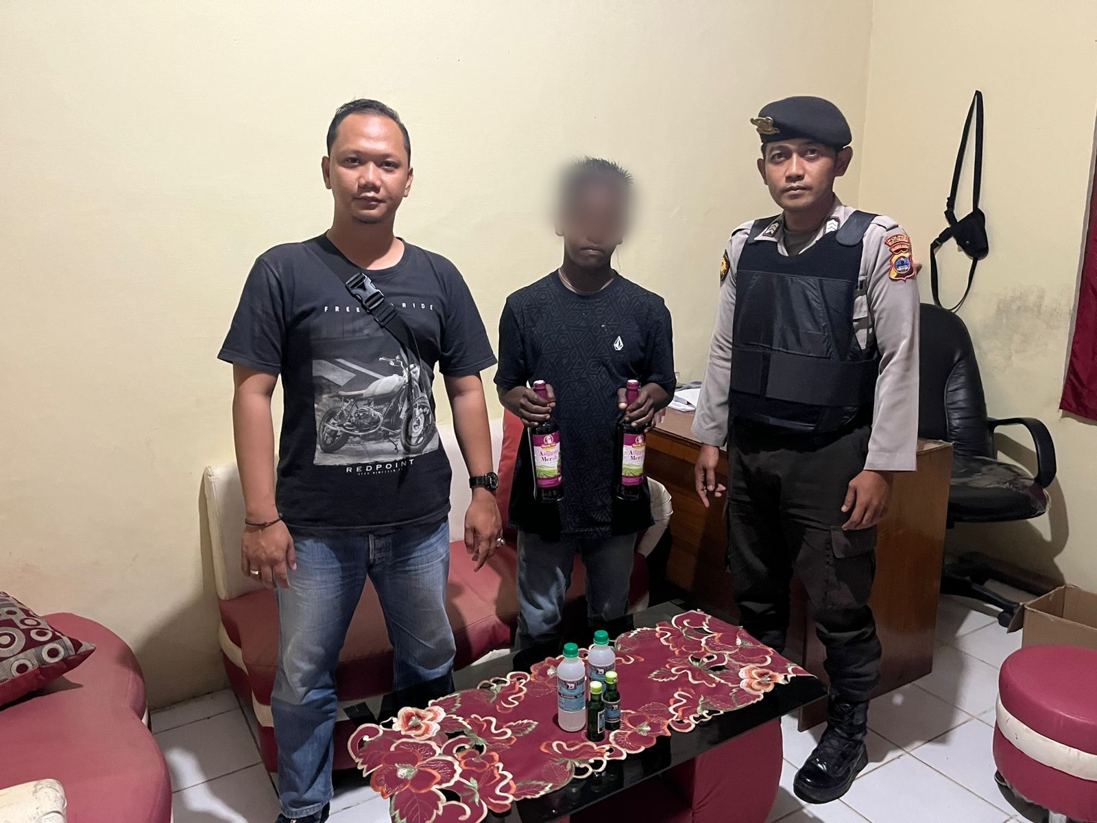 Petugas Polsek Kelumpang Tengah menunjukkan barang bukti miras dan alkohol 95 persen dari tangan pelaku R, Senin (12/5/2025).