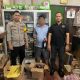 Petugas Polsek Kelumpang Tengah menunjukkan botol miras ilegal hasil sitaan dari rumah pelaku di Desa Sangsang, Selasa malam (13/5/2025).