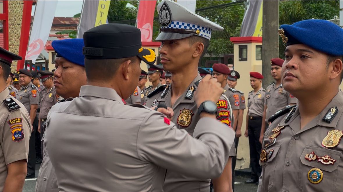 Kapolres Kotabaru AKBP Doli M. Tanjung menyematkan pangkat baru kepada personel dalam Upacara Korps Raport di halaman Mapolres, Senin (30/6/2025).