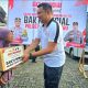 AKBP Arief Prasetya menyerahkan bantuan sosial kepada Nenek Saini (90) dalam Program Kopi Manis di Desa Gunung Antasari, Minggu (22/06/2025). Momen haru ini menghangatkan hati warga.