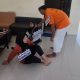 Petugas Polsek Banjarmasin Selatan mengawal tersangka M. Syamson saat memperagakan salah satu adegan pembunuhan Mahdalena dalam rekonstruksi kasus, Kamis (24/7/2025). (Foto: Humas Polsek Banjarmasin Selatan)