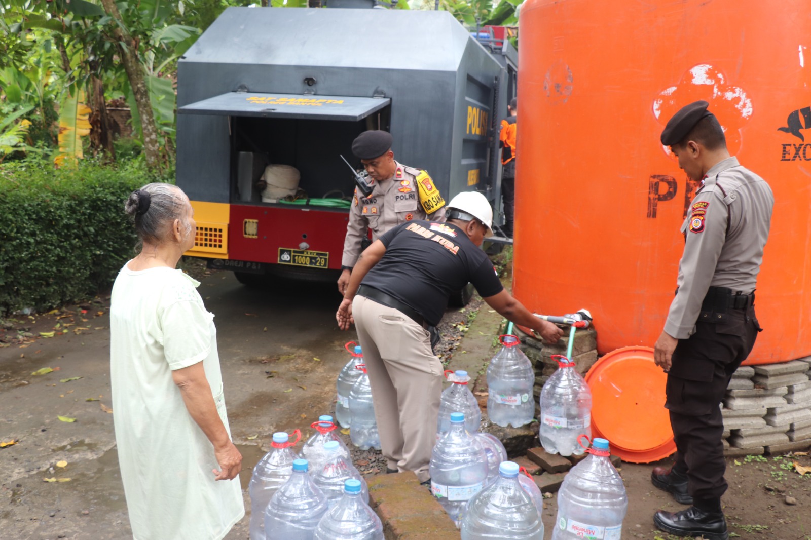 Ket Foto : Personil Polres Bantul menyerahkan langsung bantuan air bersih kepada warga Trimurti, Srandakan, Selasa (29/7/2027). (Foto: Humas Polres Bantul)