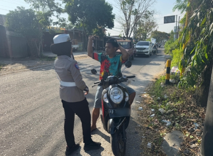 Personel Polres Bantul memberi imbauan tertib lalu lintas kepada pengendara saat Operasi Patuh Progo 2025 di simpang tiga Palbapang, Senin (21/7/2025).