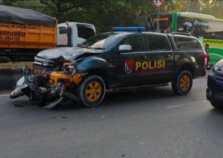 Unit mobil dinas Direktorat Samapta Polda Kalsel dan sepeda motor korban tampak di lokasi kejadian usai kecelakaan maut di jalur Banjarbaru–Banjarmasin, Minggu (27/7/2025). Kedua kendaraan terlibat langsung dalam insiden yang menewaskan satu pengendara motor.