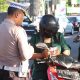 Petugas Satlantas Polres Bantul memeriksa kelengkapan surat-surat pengendara sepeda motor saat Operasi Patuh Progo 2025 di wilayah Bantul, Senin (28/7/2025).