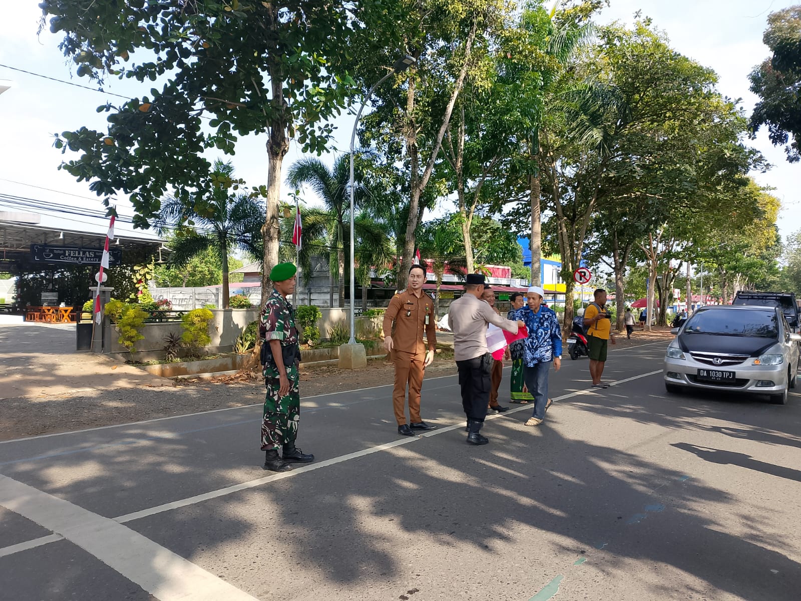 Seorang petugas kelurahan menyerahkan bendera Merah Putih kepada warga di Pelaihari, Selasa (5/8/2025), sebagai bagian dari gerakan pembagian bendera untuk menyemarakkan HUT ke-80 RI.