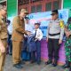 Bupati Sukamara H. Masduki menyerahkan secara simbolis paket seragam dan tas sekolah gratis kepada siswa baru di SDN Sungai Cabang Barat, Senin (11/8/2025).