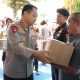 Kapolda DIY Irjen Pol Anggoro Sukartono menyerahkan bantuan sosial secara simbolis kepada warga saat kick off Gerakan Pangan Murah di halaman Mapolda DIY, Kamis (14/8/2025).