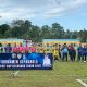 Tim sepak bola bersama wasit bersiap memulai pertandingan Bupati Cup 2025 di Stadion Bamega Kotabaru dengan semangat sportivitas.