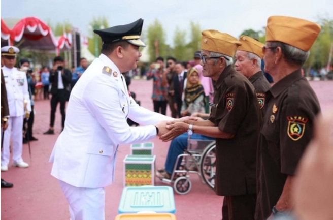 Bupati Tanah Bumbu Andi Rudi Latif menyerahkan bantuan sosial kepada masyarakat usai Upacara HUT ke-80 RI di Halaman Kantor Bupati, 18 Agustus 2025.