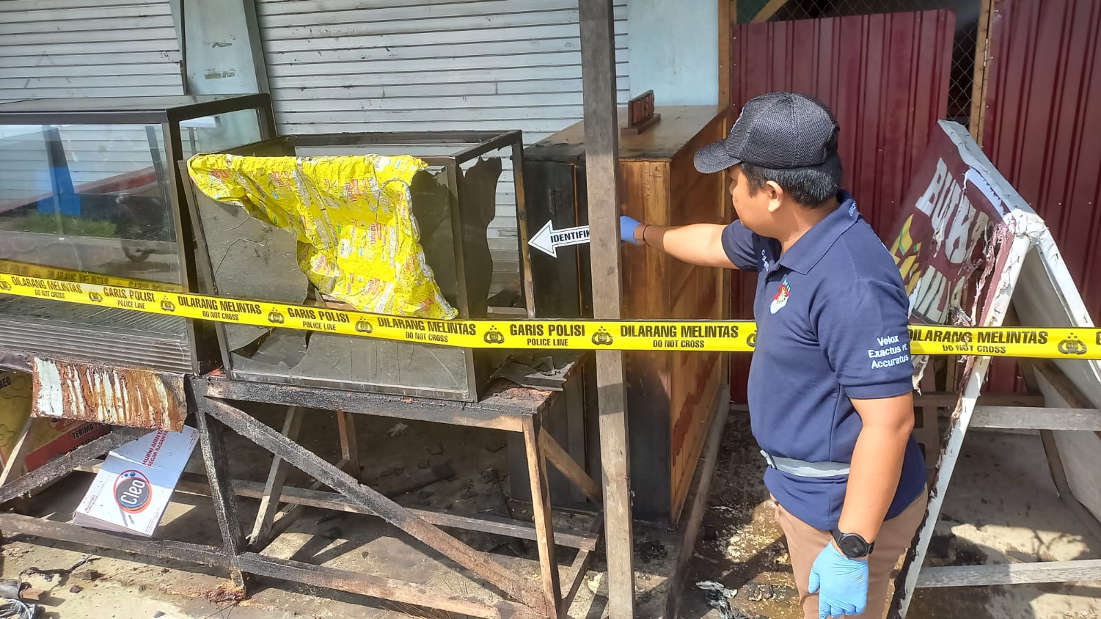 Ket Foto : Petugas kepolisian saat mengidentifikasi lokasi warung fried chicken di Kapuas usai dibakar pelaku.