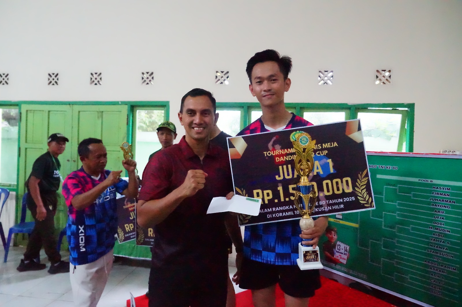 Dandim 1022/Tanah Bumbu Letkol Inf Zierda Aulia Salam menyerahkan piala kepada pemenang lomba tenis meja dalam rangka HUT TNI ke-80 di Aula Makoramil Kusan Hilir.