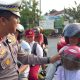Petugas Satlantas Polres Kotabaru berdialog dengan pengendara saat sosialisasi tilang elektronik (ETLE) untuk meningkatkan kesadaran berlalu lintas.