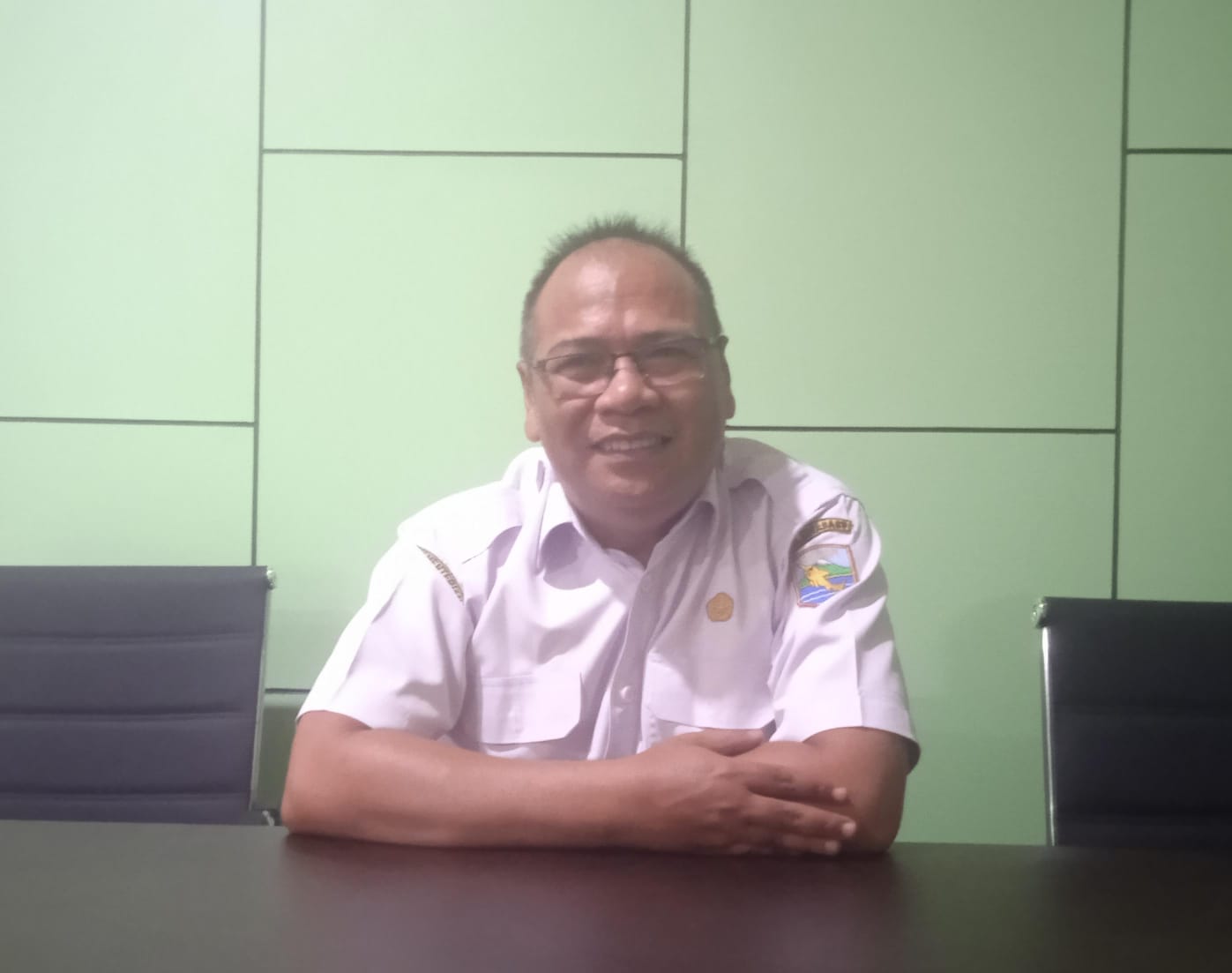 Kabid Pengaduan, Kebijakan, dan Pelaporan Layanan DPMPTSP Kotabaru, Rakhmad Syah Putra, memberikan keterangan terkait pengembangan inovasi digital dan peningkatan kualitas pelayanan publik di ruang kerjanya.