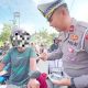 Petugas Sat Lantas Polres Kotabaru membagikan asbak portabel kepada pengendara motor sebagai bentuk edukasi larangan merokok saat berkendara.