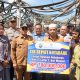 Bupati Kotabaru H. Muhammad Rusli, S.Sos menyerahkan bantuan CSR Bank Kalsel senilai Rp700 juta kepada pedagang korban kebakaran Pasar Kemakmuran, Selasa (7/10/2025). (Foto: Diskominfo Kotabaru)