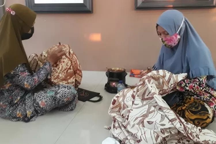 Para perajin Batik Rifaiyah di Kabupaten Batang tengah menorehkan malam pada kain. Batik ini dikenal sarat makna religius dan filosofi hidup sederhana. (Foto: Dok. Istimewa)