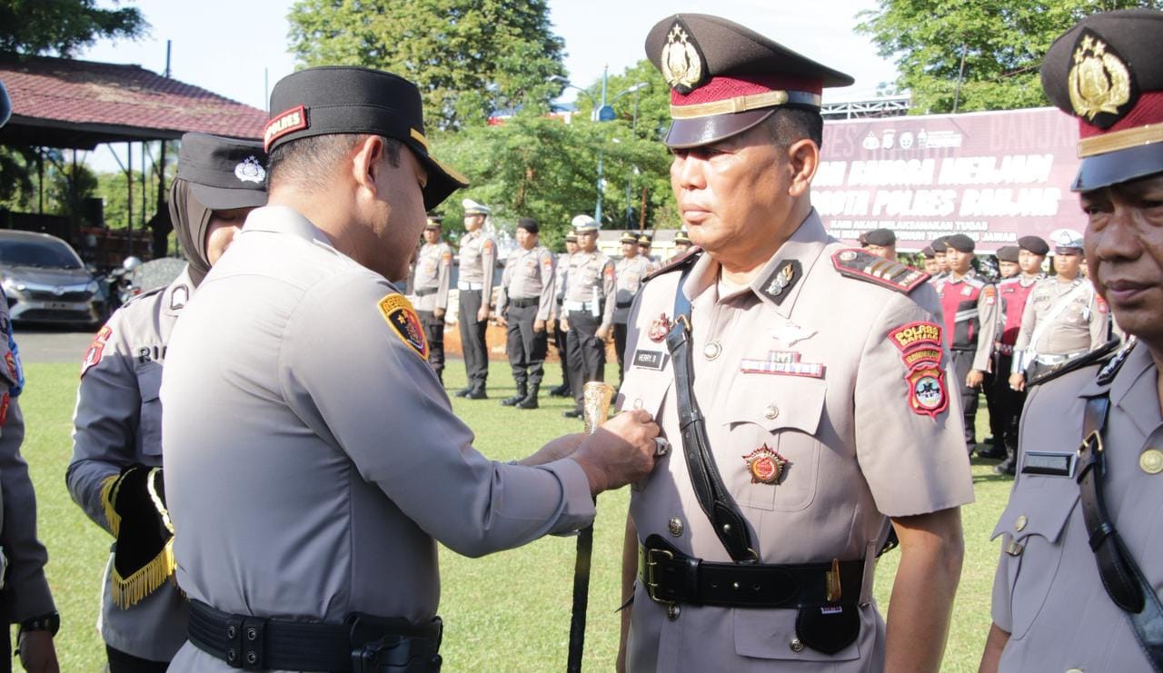 Kapolres Banjar AKBP Fadli menyematkan lencana jabatan kepada anggota Polres Banjar dalam upacara Sertijab.