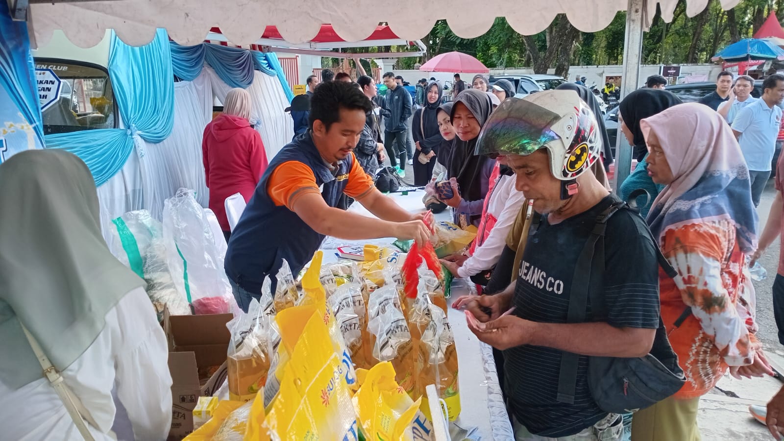 Warga antre membeli minyak goreng murah dalam kegiatan Gerakan Pangan Murah Polda Kalsel di Car Free Day Banjarmasin.