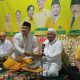 Ketua DPD Partai Golkar Kota Banjarbaru Gusti Rizky Sukma Iskandar Putera menyerahkan potongan tumpeng kepada Tuan Guru Syaifullah saat peringatan HUT ke-61 Partai Golkar di Majelis Alfatih Wali Imdad, Banjarbaru.