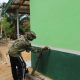 Satgas TMMD Kodim 1022 Tanah Bumbu dan warga Desa Rejosari melakukan pengecatan rumah warga dalam program rehab RTLH.