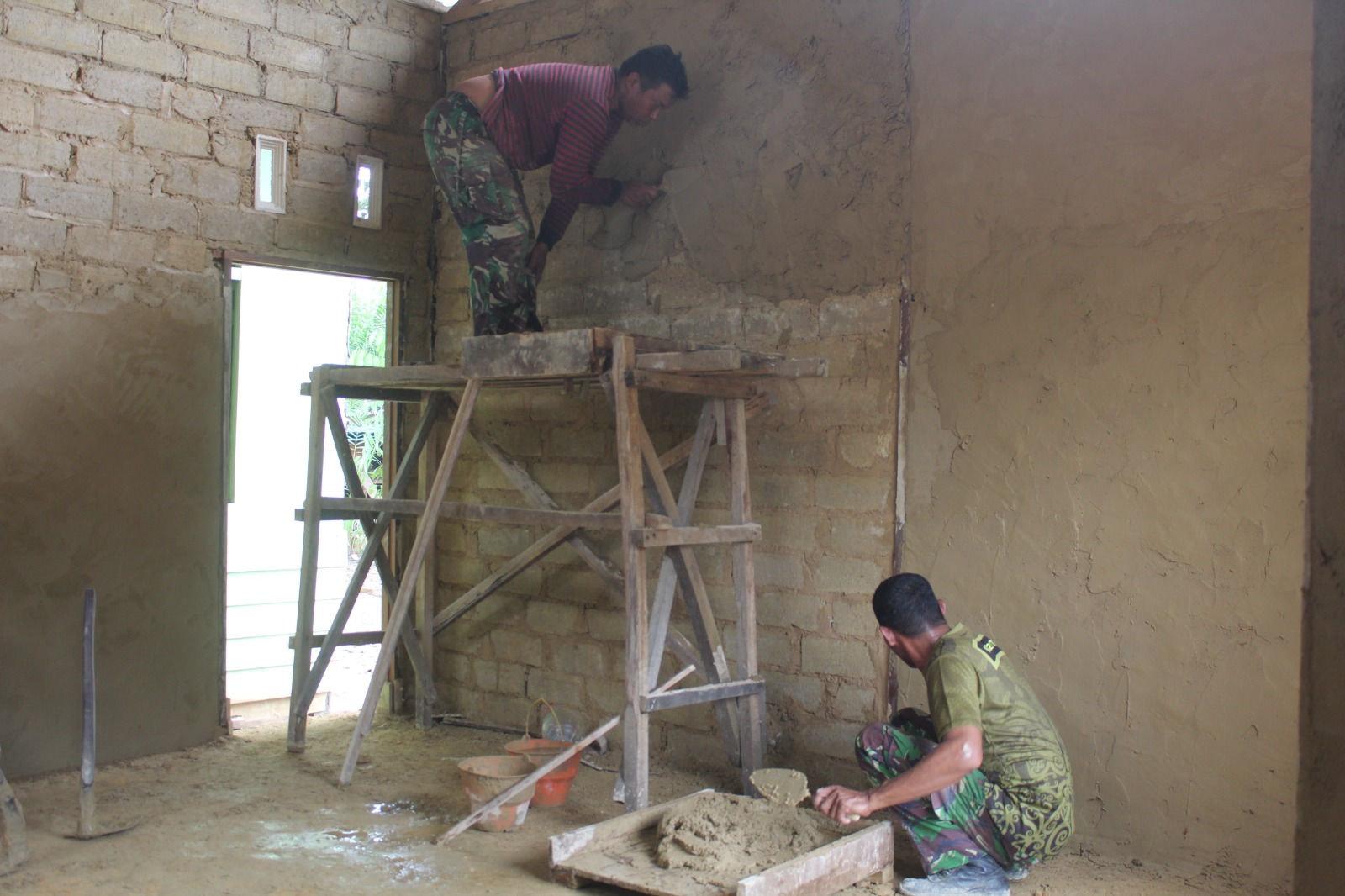 Satgas TMMD Kodim 1022 Tanah Bumbu bersama warga melaksanakan pemlasteran rumah warga Desa Rejosari sebagai bagian dari rehab RTLH.