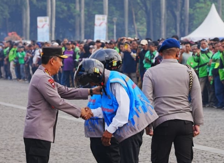 Kapolri Listyo Sigit Prabowo berjabat tangan dengan perwakilan ojek online pada Apel Ojol Kamtibmas di Monas, Jakarta.