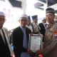 Kompol Slamet Hari Wahyudi dari Polres Tabalong menyerahkan piagam penghargaan kepada perwakilan pondok pesantren pada upacara Hari Santri Nasional 2025 di Pendopo Bersinar Tabalong.