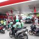 Para pengemudi ojek online sedang mengisi BBM Pertamina di SPBU, mencerminkan kepercayaan terhadap efisiensi dan kualitas bahan bakar untuk mobilitas harian.