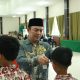Plt. Asisten Pemerintahan dan Kesra Tanah Bumbu, M. Putu Wisnu Wardhana, mewakili Bupati menyerahkan kacamata gratis kepada salah satu siswa dalam kegiatan bakti sosial HUT ke-80 TNI di Aula Kodim 1022/Tanah Bumbu.