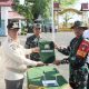 Bupati Barito Kuala H. Bahrul Ilmi menyerahkan alat kerja kepada personel TNI dalam pembukaan TMMD ke-126 di halaman Kantor Bupati, Rabu (8/10/2025).