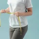 Wanita dengan tubuh ideal mengenakan pakaian olahraga, menggambarkan hasil dari gaya hidup sehat dan kebiasaan rutin berolahraga.
