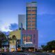 Gedung ARTOTEL TS Suites Surabaya pada malam hari dengan pencahayaan fasad yang terang, menjadi venue utama perayaan akhir tahun dan program Semarak Akhir Tahun 2025.
