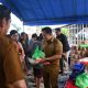 Bupati Pulang Pisau H Ahmad Rifa’i menyerahkan paket pasar murah secara simbolis kepada warga dalam kegiatan pasar penyeimbang di Desa Lawang Uru, Banama Tingang.
