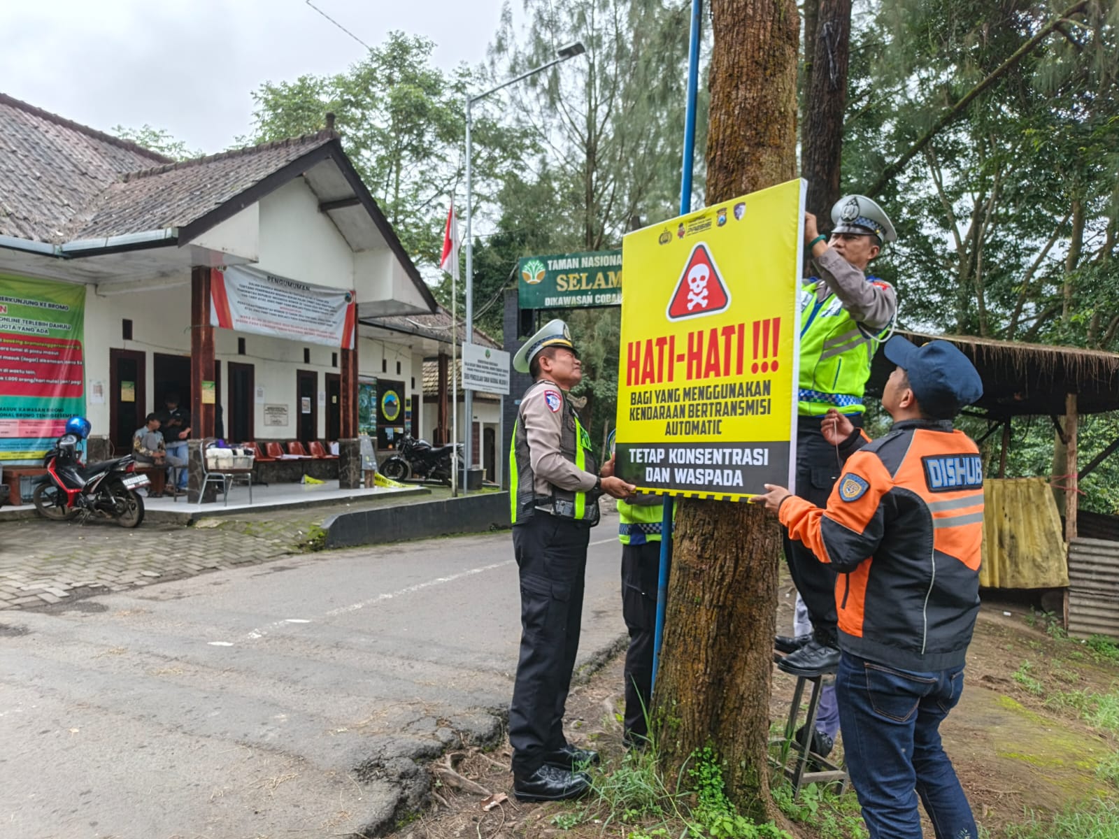 Petugas Satlantas Polres Malang memasang banner keselamatan di jalur wisata Bromo menjelang libur Nataru