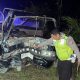 Polisi memeriksa minibus rusak berat setelah kecelakaan lalu lintas di jalan nasional pada malam hari