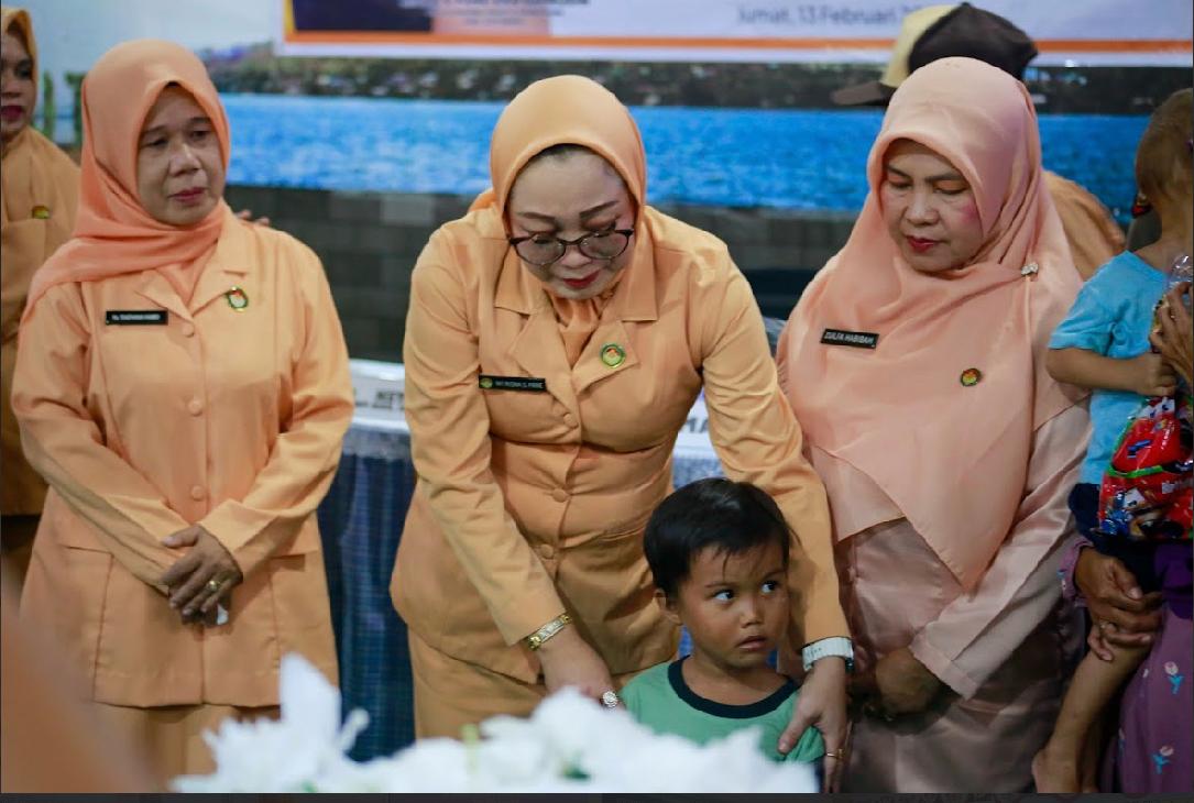 Ketua DWP Kotabaru menyerahkan santunan kepada anak yatim dalam kegiatan pertemuan Dharma Wanita Persatuan di Pulau Sembilan.