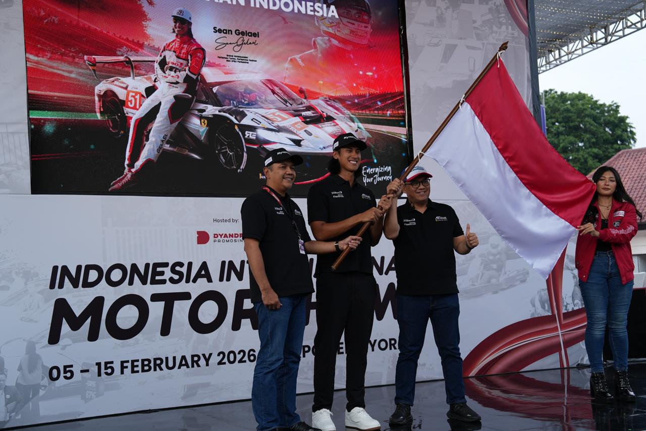 Sean Gelael dan perwakilan Pertamina Patra Niaga mengibarkan bendera Indonesia pada peluncuran kerja sama balap internasional AF Corse 51 di IIMS 2026 Jakarta.