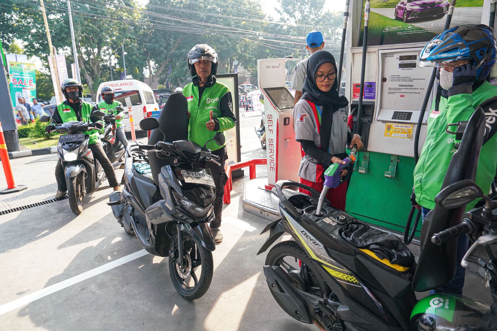 Petugas SPBU mengisi BBM motor ojek online menggunakan layanan MyPertamina saat promo diskon Pertamax berlangsung.