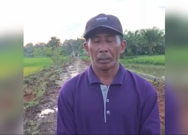 Panut, warga Desa Sumber Makmur Takisung, berdiri di jalur jalan desa yang tengah diperbaiki sebagai respons cepat atas usulan warga.