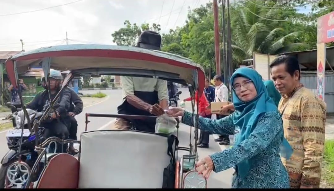Ket Foto: Camat Selat Syarifullah, S.P., M.P, didampingi Ketua TP PKK Kecamatan Selat, Firmanianti Syarifullah, S.Pd, bersama sejumlah staf kecamatan saat berbagi takjil ke pengguna jalan yang melintas di depan kantor kecamatan, (Kamis 5/3/2026) sore.