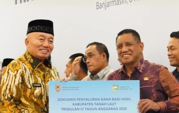 Gubernur Kalsel H Muhidin menyerahkan dana bagi hasil pajak daerah kepada Wakil Bupati Tanah Laut Zazuli di Banjarmasin.