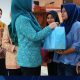 Ketua DWP Kalsel Masrupah Syarifuddin menyerahkan bantuan kepada peserta dalam kegiatan Gerakan Aksi Remaja Keluarga Berkualitas untuk pencegahan stunting di Tanah Laut.