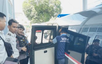 Petugas lapas dan polisi mengawal warga binaan saat dimasukkan ke kendaraan tahanan dalam proses pemindahan dari Lapas Batulicin ke Kotabaru.