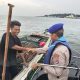 Personel Sat Polairud Polres Kotabaru membagikan sembako kepada nelayan di perairan Selat Laut.