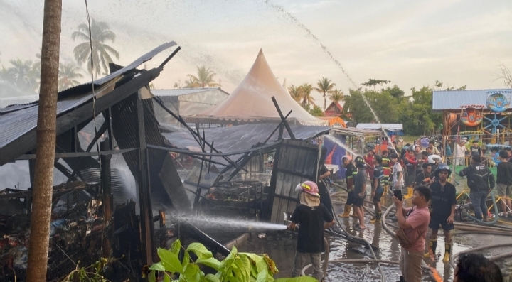 Petugas damkar memadamkan kebakaran di pusat kuliner Puja Sera Palangka Raya yang membakar sejumlah lapak dan dua sepeda motor.