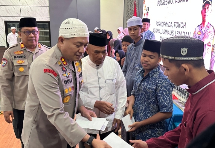 Kapolres Kotabaru AKBP Doli M. Tanjung bersama Bupati Kotabaru menyerahkan santunan kepada anak yatim dalam kegiatan buka puasa bersama.