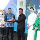 bupati tanah bumbu andi rudi latif dan asty ananta menyerahkan bibit tomat cherry stevia kepada petani di batulicin